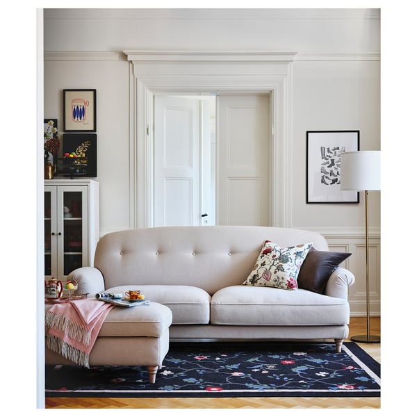 ESSEBODA beige sofa, elegant, tucked legs, floral cushions, soft fabric, bright room, art decor.