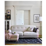ESSEBODA beige sofa, elegant, tucked legs, floral cushions, soft fabric, bright room, art decor.