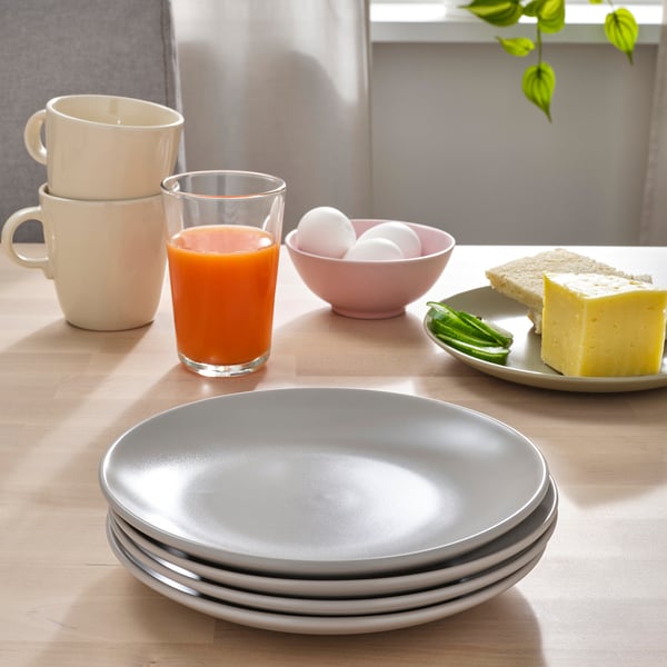 Table setting with FÄRGKLAR plates, cups, and food.