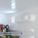A small fridge interior with shelves and a temperature control panel. Led light illuminates food and adjustable compartments are visible.
