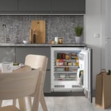 Modern kitchen with FASTNÄS fridge, shelves, and food.