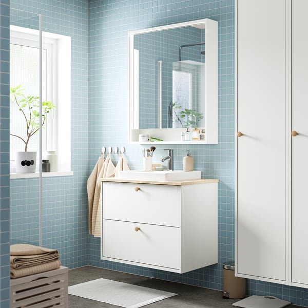 Modern bathroom with FAXÄLVEN white mirror cabinet, large mirror, storage, lighting, and hanging towels.