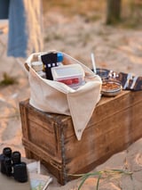 Image a FINSKUREN cutlery set in a beige fabric case on a wooden box. Includes knife, spoon, fork, and other small items.
