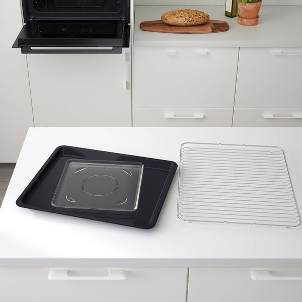 Modern kitchen with FINSMAKARE oven. Displays baking tray, wire rack, and loaf on counter.