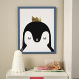 Framed penguin print above table with lamp, books, and toy. Safe edges, can hang horizontally or vertically.