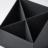 Black four-compartment paperboard desk organizer, neatly assembled, viewed from above.