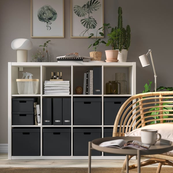 Modern living room with kallax shelf, wicker chair, and wall art.