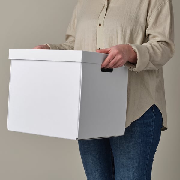 Person holding white storage box with cut-out handles, ideal for kallax shelving.