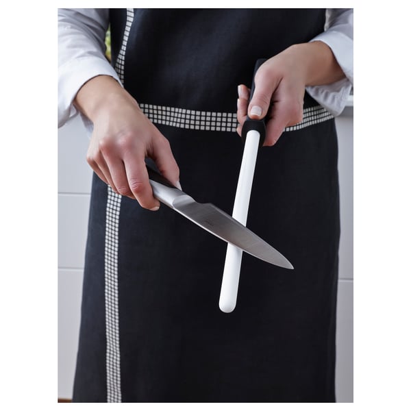 Person holding a knife sharpener, prepared to sharpen a knife.
