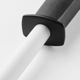 Knife sharpener with black plastic handle, white porcelain rod, sharpens knives efficiently.