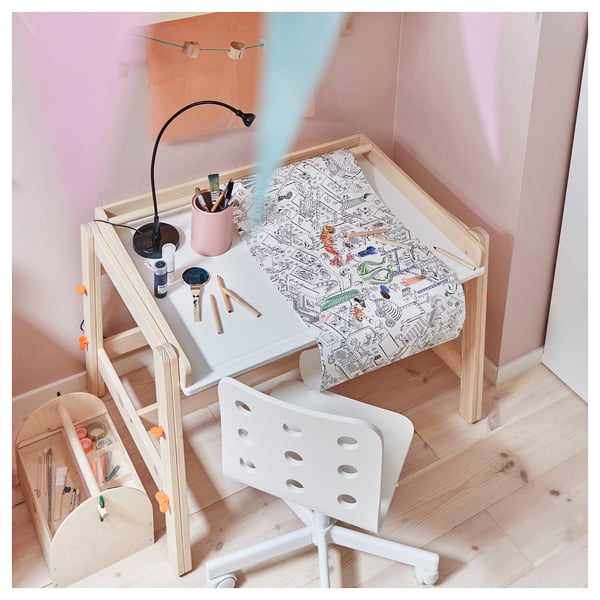Kids white wooden desk with adjustable height, slanted top, and drawing roll holder. Includes a white plastic chair and multiple art supplies.
