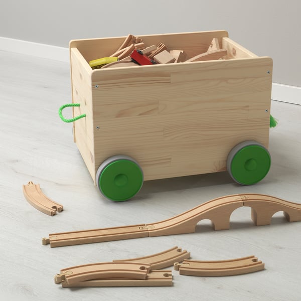 Wooden toy cart with green wheels stores and transports toys.
