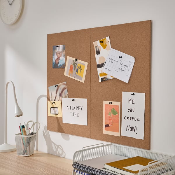 Cork board with photos, notes, and quotes on wall above desk. Or wall-mounted cork board with photos, notes, and quotes above desk.