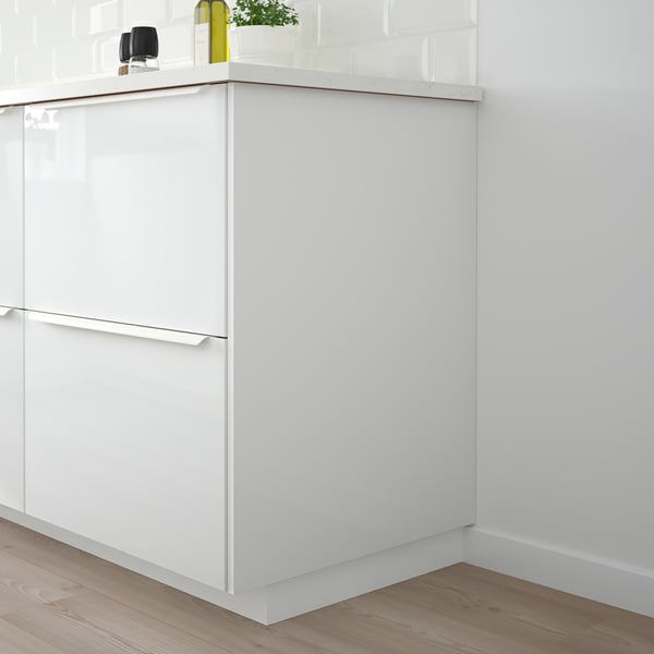 White FÖRBÄTTRA kitchen island with glossy surfaces and metallic handles on wooden floor.