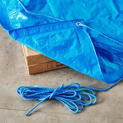 Blue tarpaulin and rope, with box and more rope, for securing loads.