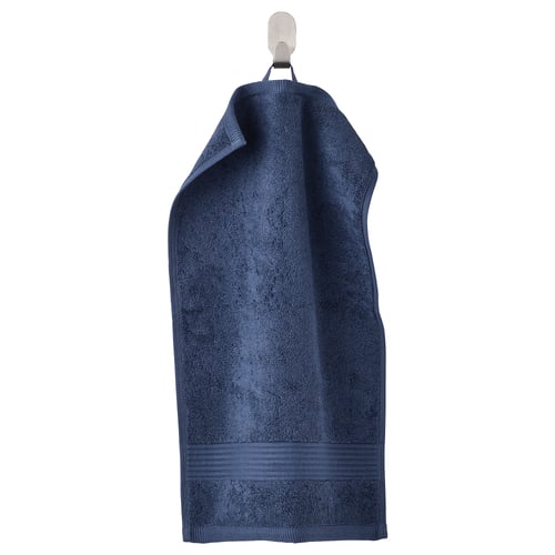 A deep blue, thick FREDRIKSJÖN towel hangs neatly from a hook. Made of soft, absorbent 100% cotton with a woven border.