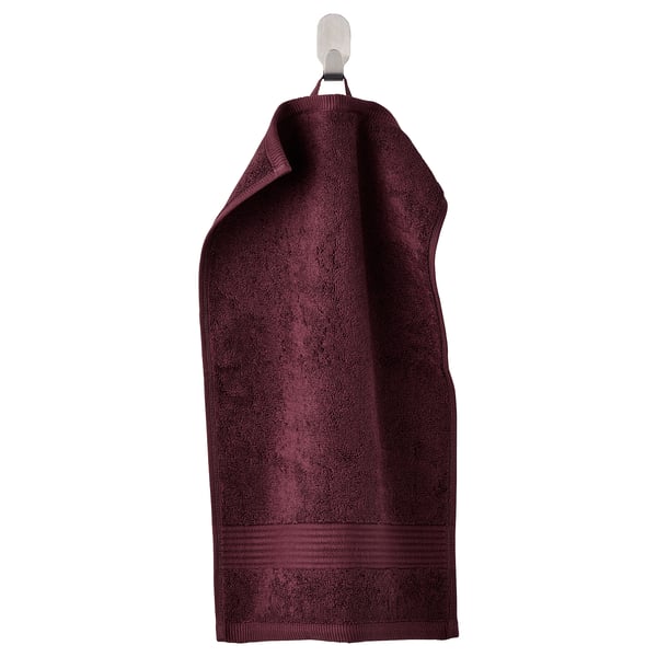 Dark maroon FREDRIKSJÖN cotton towel with ribbed edges hanging.