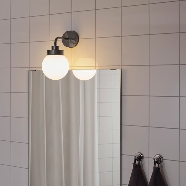 Two globe lights on wall for bathroom, warm glow.
