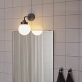 Two globe lights on wall for bathroom, warm glow.