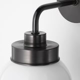 Modern wall lamp with frosted glass shade and black metal arm.