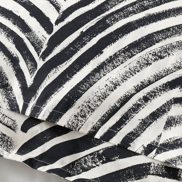 Black and white striped pillowcase with irregular patterns. ;