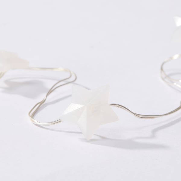 White star-shaped led light chain on a clean, minimalist surface, highlighting quality and simplicity.