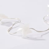 White star-shaped led light chain on a clean, minimalist surface, highlighting quality and simplicity.