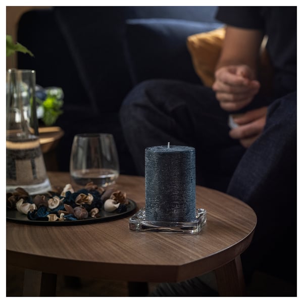 Dim room, person on couch, candle, decorative items.