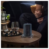 Dim room, person on couch, candle, decorative items.