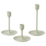 Three light green candlesticks in varying heights, simple modern design, made of aluminum with felt pads, arranged in a triangle.
