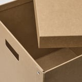 Open cardboard box with handles, showing sturdy, recycled material.