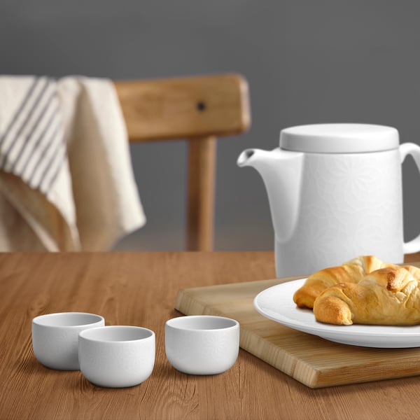 GOKVÄLLÅ white kava cups & teapot. Small, durable, textured cups & large teapot on wooden table.