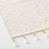 Handwoven cotton-blend table runner with multi-colored tassels.
