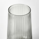 Clear glass vase with ribbed texture, standing upright against white background.