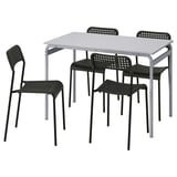 Black plastic chairs and gray metal table set. Modern, stackable design.