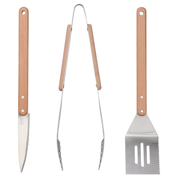 Three grilling tools: knife, tongs, spatula with wooden handles in v-shape formation against white background.