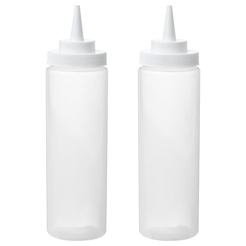 Two white squeeze bottles, empty, standing upright with caps on.