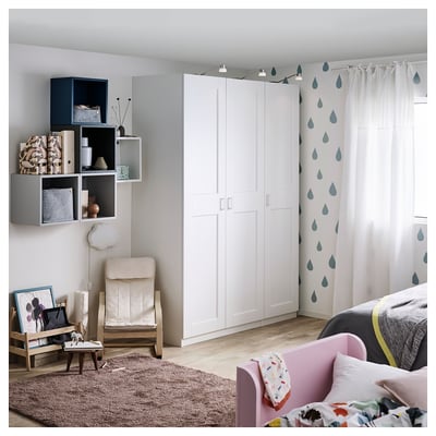 A modern bedroom with a white GRIMO wardrobe, featuring clean, bold frames and a beveled edge design.
