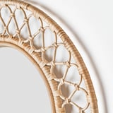 Rattan-woven mirror with intricate design, reflecting quality craftsmanship.