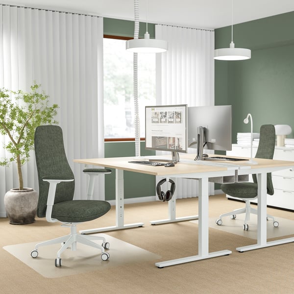 Modern office setup with two GRÖNFJÄLL chairs in green, a white desk with two computers, and a large window with white curtains.