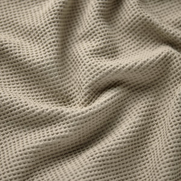 Folded waffle towel, light beige, textured pattern.