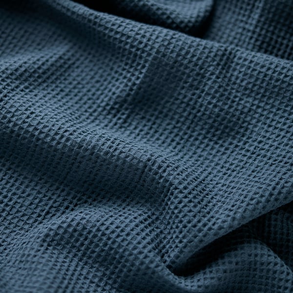 Deep blue, textured towel with tight, even weave, folded neatly.