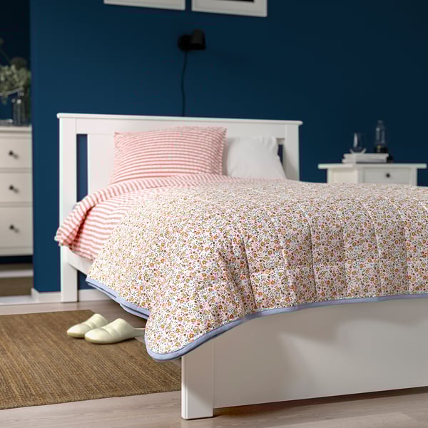 Floral bedspread with striped reverse, matching headboard and slippers.