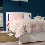 Floral bedspread with striped reverse, matching headboard and slippers.