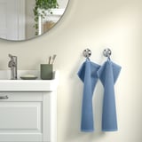Bathroom with sink, mirror, & GULVIAL towels. Green toothbrush holder & soap dish. Mirror reflects plant.