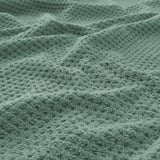 Close-up of soft, plush green towel showcasing its thick, textured weave.