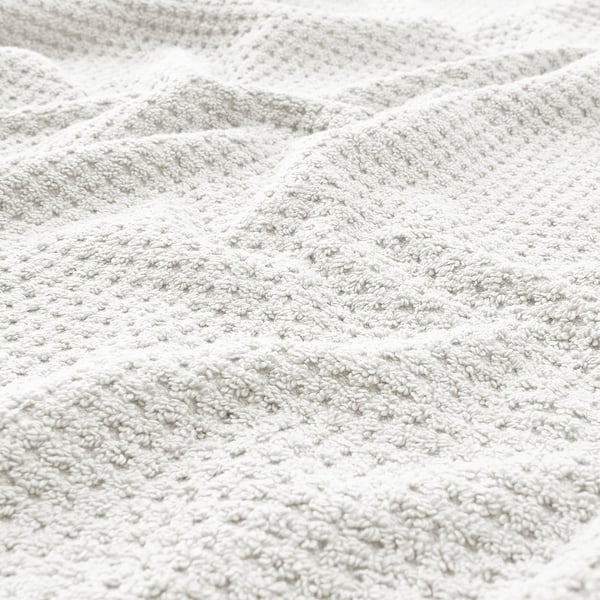 Close-up of soft, beige cotton towel showcasing its fluffy texture and thickness.