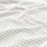 Close-up of soft, beige cotton towel showcasing its fluffy texture and thickness.