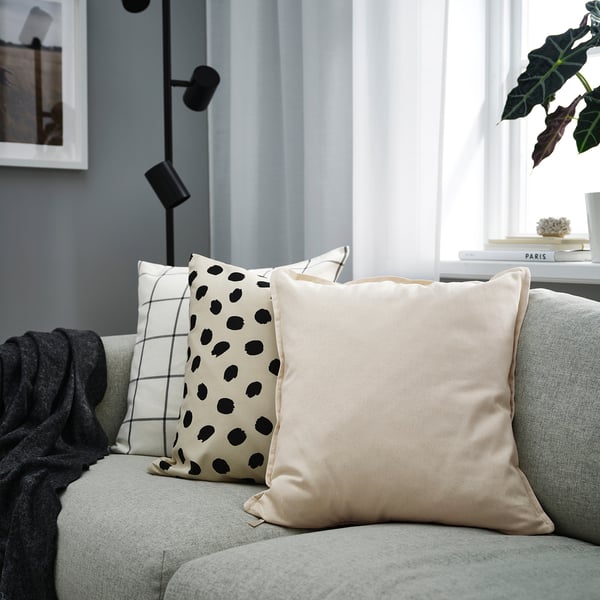 Neutral-toned pillows on gray couch; GURLI patterns, black dots & grid, tan solid. Large.