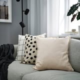 Neutral-toned pillows on gray couch; GURLI patterns, black dots & grid, tan solid. Large.